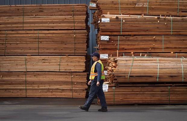 A worker walks past stacks of lumber at the Partap Forest Products mill in Maple Ridge, B.C.