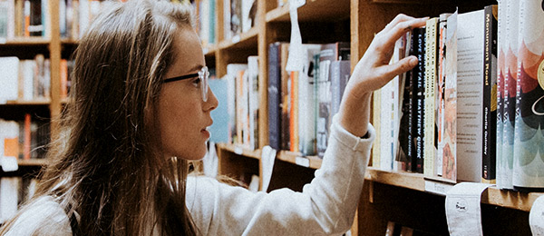 Woman searching bookshelf