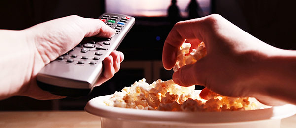 TV remote and plate of popcorn