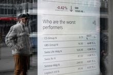 A man watches a market board at the headquarters of Swiss giant banking UBS in Zurich on March 20, 2023. - UBS share price plunged on March 20, 2023 as a deal to take over its troubled Swiss rival Credit Suisse for $3.25 billion failed to calm stock market nerves. (Photo by Fabrice COFFRINI / AFP) (Photo by FABRICE COFFRINI/AFP via Getty Images)