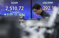 A currency trader watches monitors near the screens showing the Korea Composite Stock Price Index (KOSPI), left, and the foreign exchange rate between U.S. dollar and South Korean won at the foreign exchange dealing room of the KEB Hana Bank headquarters in Seoul, South Korea, Thursday, Nov. 30, 2023. Asian shares were mostly higher Thursday ahead of an update on U.S. consumer inflation and a meeting of oil producers in Vienna. (AP Photo/Ahn Young-joon)