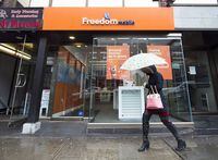 A women walks past the new rebranding sign of Freedom Mobile in Toronto on Thursday, November 24, 2016. Globalive Capital has signed a network sharing deal with Telus Corp. to bid on Shaw Communications Inc.'s Freedom Mobile. THE CANADIAN PRESS/Nathan Denette