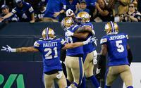 Winnipeg Blue Bombers' Jackson Jeffcoat (94), right, celebrates his touchdown from a fumble recovery against the Calgary Stampeders during the second half CFL action in Winnipeg Thursday, August 25, 2022. The play was called back for roughing the passer.   THE CANADIAN PRESS/John Woods