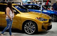 FILE - In this March 28, 2019, file photo a car shopper looks over a BMW X2 at the auto show in Denver. While the purchase of a new luxury vehicle is out of reach for many shoppers, buying a used 3-year-old version could be an intriguing option compared to buying a fully loaded non-luxury new vehicle for a similar price. (AP Photo/David Zalubowski, File)