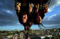 08062022Kate McClure and Daphne Tannas of Hamiota, Manitoba, ride the Ring of Fire midway ride during the opening night of the Manitoba Summer Fair in Brandon on Wednesday. (Tim Smith for The Globe and Mail)