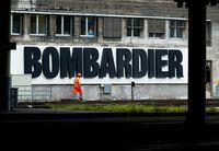 FILE PHOTO: A worker walks in front of a Bombardier advertising board at the SBB CFF Swiss railway train station in Bern, Switzerland, October 24, 2019. REUTERS/Denis Balibouse/File Photo
