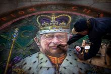 British Artist Julian Beaver gives the finishing touches to his work based on an image of King Charles in London.