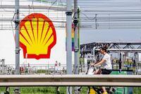 A woman rides her bicycle past the Shell Pernis site in Rotterdam on July 30, 2020.