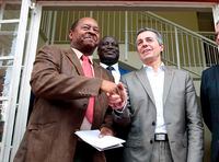 FILE — In this Jan. 9, 2019 file photo Federal Councilor Ignazio Cassis, right, of Switzerland, shakes hands with Zimbabwean Health Minister, Obadiah Moyo, left, in Harare. Moyo, who appeared in court Saturday, June 20, 2020 was arrested Friday by the Zimbabwe Anti-Corruption Commission and is accused of illegally awarding a $42 million tender to a company for a supply of COVID-19 drugs and personal protective equipment while aware the company was not a pharmaceutical supplier but a consultancy firm. (AP Photo/Tsvangirayi Mukwazhi, File)
