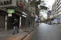 A man walks along an empty street during a general strike by public transport and labor unions paralyzed Lebanon in protest the country's deteriorating economic and financial conditions in Beirut, Lebanon, Thursday, Jan. 13, 2022. (AP Photo/Bilal Hussein)