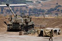 A soldier walks near an Israeli army self propelled artillery vehicle on the outskirts of Kiryat Shmona near Israel's border with Lebanon on July 6, 2023. The Israeli army said it was conducting strikes on southern Lebanon after a mortar launched from its northern neighbour exploded in the border area between the two foes. The latest military action was launched three months after the two countries saw their worst cross-border fire in years. (Photo by JALAA MAREY / AFP) (Photo by JALAA MAREY/AFP via Getty Images)