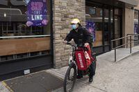 FILE - A delivery man bikes with a food bag from Grubhub on April 21, 2021, in New York. Uber Eats, DoorDash and Grubhub sued New York City on Thursday, July 6, 2023, to block its new minimum pay rules for food delivery workers. (AP Photo/Mark Lennihan, File)