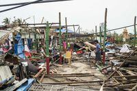 Local residents walk past damaged buildings after Cyclone Mocha in Sittwe township, Rakhine State, Myanmar, Tuesday, May 16, 2023. Myanmar’s military information office said the storm had damaged houses and electrical transformers in Sittwe, Kyaukpyu, and Gwa townships. (AP Photo)