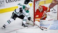 Dallas Stars forward Sam Steel, left, tries to wrap the puck around Calgary Flames goalie Jacob Markstrom during second period NHL hockey action in Calgary, Wednesday, Nov. 1, 2023.THE CANADIAN PRESS/Jeff McIntosh