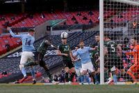 Manchester City's Aymeric Laporte, left, scores the opening goal during the English League Cup final soccer match between Manchester City and Tottenham Hotspur at Wembley stadium in London, Sunday, April 25, 2021. (AP Photo/Alastair Grant)