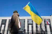 A pro-Ukrainian supporter waves the country's flag outside the Russian embassy, Thursday, Feb. 24, 2022 in Ottawa.  THE CANADIAN PRESS/Adrian Wyld