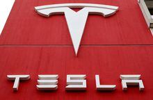 FILE PHOTO: The logo of car manufacturer Tesla is seen at a branch office in Bern, Switzerland October 28, 2020. REUTERS/Arnd Wiegmann/File Photo