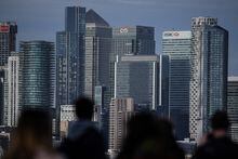 People look at Canary Wharf financial district, from Greenwich Park, south east London, on Feb. 10.