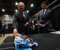 Canadian Prime Minister Justin Trudeau looks on as German Chancellor Olaf Scholz examines a hydrogen powered model car as they tour a trade show, Tuesday, August 23, 2022 in Stephenville, Newfoundland and Labrador.  THE CANADIAN PRESS/Adrian Wyld