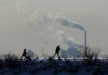 People cross-country ski in the cold weather as an industrial plant is shown in the back ground in Toronto on Friday, Feb. 4, 2022. THE CANADIAN PRESS/Nathan Denette