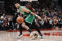 Boston Celtics Jayson Tatum, left, and Toronto Raptors Pascal Siakam eye a loose ball during first half NBA basketball action in Toronto, Monday, Dec. 5, 2022.&nbsp;Tatum had 31 points and 12 rebounds to lift the league-leading Boston Celtics to a 115-110 victory over the Toronto Raptors on Monday. THE CANADIAN PRESS/Chris Young