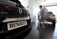 A customer walks near a vehicle at a Renault carmaker dealer amid the coronavirus disease (COVID-19) outbreak in Sint-Pieters-Leeuw, Belgium May 29, 2020.  REUTERS/Yves Herman REFILE - CORRECTING LOCATION