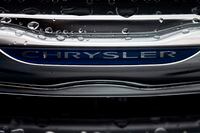 In this Dec. 2, 2014, file photo, a Chrysler minivan sits under rain at a car lot in San Diego.