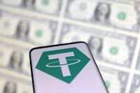 FILE PHOTO: Smartphone with Tether logo is placed on displayed U.S. dollars in this illustration taken, May 12, 2022. REUTERS/Dado Ruvic/Illustration/File Photo/File Photo