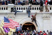 FILE PHOTO: A mob of supporters of U.S. President Donald Trump fight with members of law enforcement at a door they broke open as they storm the U.S. Capitol Building in Washington, U.S., January 6, 2021. REUTERS/Leah Millis/File Photo