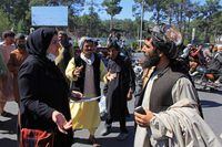 An Afghan woman protester speaks with a member of the Taliban, right, during a protest in Herat on Sept. 2, 2021. Defiant Afghan women held a rare protest on Sept. 2 saying they were willing to accept the all-encompassing burqa if their daughters could still go to school under Taliban rule.
