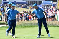Europe's Scottish golfer, Robert MacIntyre (L) is congratulated by Europe's English golfer, Justin Rose (R) after holing his putt on the 1st green during his four-ball match on the first day of play in the 44th Ryder Cup at the Marco Simone Golf and Country Club in Rome on September 29, 2023. (Photo by Andreas SOLARO / AFP) (Photo by ANDREAS SOLARO/AFP via Getty Images)
