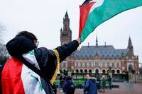 A man waves a Palestinian flag as people protest on the day of a public hearing held by The International Court of Justice (ICJ) to allow parties to give their views on the legal consequences of Israel's occupation of Palestinian territories before eventually issuing a non-binding legal opinion, in The Hague, Netherlands, February 21, 2024. REUTERS/Piroschka van de Wouw