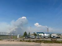 Smoke is seen burning in the distance at the Fort Chipewyan Airport on May 30, 2023. An evacuation order went into effect for Fort Chipewyan, a hamlet with a population of about 800 people, on Tuesday and includes the Athabasca Chipewyan First Nation, Mikisew Cree First Nation, Fort Chipewyan Métis Nation and the Regional Municipality of Wood Buffalo. The wildfire, about 86-square-kilometres in size, is a short distance from the local airport.