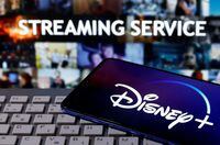 A smartphone with the "Disney" logo is seen on a keyboard in front of the words "Streaming service" in this picture illustration taken March 24, 2020.