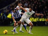 Newcastle United's Jamaal Lascelles, right, and Sheffield Wednesday's Reece James battle for the ball during the English FA Cup third round soccer match between Sheffield Wednesday and Newcastle United at the Hillsborough Stadium, in Sheffield, Saturday, Jan. 7, 2023. (Nick Potts/PA via AP)