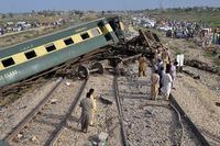 Local residents examine damaged cars of a passenger train which was derailed near Nawabshah, Pakistan, Sunday, Aug. 6, 2023. Railway officials say some passengers were killed and dozens more injured when a train derailed near the town of Nawabshah in southern Sindh province. (AP Photo/Pervez Masih)