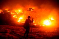 A firefighter works at the scene of the Bobcat Fire burning on hillsides near Monrovia Canyon Park, in Monrovia, Calif., on Sept. 15, 2020.