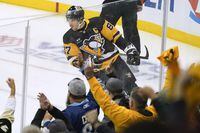 Fans cheer as Sidney Crosby celebrates his goal during the first period of the team's NHL hockey game against the Arizona Coyotes, Thursday, Oct. 13, 2022, in Pittsburgh. (AP Photo/Keith Srakocic)