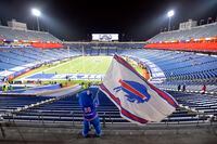 FILE - Buffalo Bills fans leave Bills Stadium as a mascot waves a flag after an NFL divisional round football game against the Baltimore Ravens, Jan. 16, 2021, in Orchard Park, N.Y. State and county taxpayers will be asked to commit $850 million in public funds toward construction of the Buffalo Bills' new stadium, which has a state-projected price tag of $1.35 billion, a person familiar with the the plan told The Associated Press on Monday, March 28, 2022. (AP Photo/Adrian Kraus, File)
