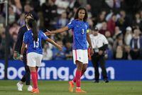 FILE - France's team captain Wendie Renard, right, touches hands with Selma Bacha at the end of the Women Euro 2022 semifinal soccer match between Germany and France at Stadium MK in Milton Keynes, England, Wednesday, July 27, 2022. The United States will be playing for an unprecedented three-peat at the Women's World Cup this summer. Among the teams that will challenge the United States are two-time World Cup winners Germany and the 2022 Women's Euro winner, England. Brazil and France could also threaten the perennially dominant Americans. (AP Photo/Alessandra Tarantino, File)