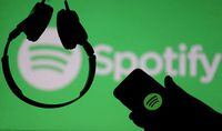 FILE PHOTO: A smartphone and a headset are seen in front of a screen projection of Spotify logo, in this picture illustration taken April 1, 2018. REUTERS/Dado Ruvic/Illustration