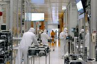 FILE PHOTO: Workers work inside the clean room of U.S. semiconductor manufacturer SkyWater Technology Inc where computer chips are made, in Bloomington, Minnesota, U.S., April, 2022 in this handout picture acquired by Reuters on July 19, 2022. SkyWater Technology/Handout via REUTERS/File Photo