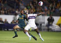 Vancouver Whitecaps forward Cristian Dajome, right, and LA Galaxy forward Raheem Edwards watch the ball during the first half of an MLS soccer match in Carson, Calif., Saturday, March 18, 2023. (AP Photo/Ringo H.W. Chiu)