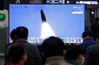 People watch a television showing a file image of a North Korean missile launch during a news program at the Suseo Railway Station, in Seoul, South Korea, on March 25, 2021.
