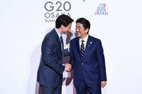 Canada's Prime Minister Justin Trudeau (L) is welcomed by Japan's Prime Minister Shinzo Abe for a family photo session at the G20 Summit in Osaka on June 28, 2019. (Photo by Brendan Smialowski / AFP)BRENDAN SMIALOWSKI/AFP/Getty Images
