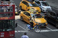 NEW YORK, NY - JULY 30: A cyclist navigates around taxi cabs on 7th Avenue in Midtown Manhattan on July 30, 2019 in New York City. As the nation's largest city tries to balance an increasing number of bicyclists along its streets, the numbers of bike riders killed and injured continues to rise. Another cyclist was killed in Brooklyn on Monday, bringing the total to 18 cyclist fatalities on New York City streets so far in 2019. New York City Mayor Bill de Blasio has vowed to increase bike safety, announcing a nearly $60 million plan to enhance bike safety and add protected bike lanes throughout the city. (Photo by Drew Angerer/Getty Images)