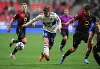 Vancouver Whitecaps' Ryan Gauld (25) chases down the ball as Valour FC's Diego Gutierrez, right, defends during the second half of a preliminary round Canadian Championship soccer match, in Vancouver, on Wednesday, May 11, 2022. THE CANADIAN PRESS/Darryl Dyck