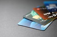 stack of multicolored credit cards on black background