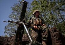 FILE PHOTO: A Ukrainian service member from a 28th separate mechanised brigade named after the Knights of the Winter Campaign of the Armed Forces of Ukraine, prepares to fire a mortar at his positions at a front line, amid Russia's attack on Ukraine, near the city of Bakhmut in Donetsk region, Ukraine May 18, 2023. REUTERS/Sofiia Gatilova