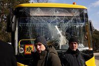 NOVOIAVORISK, UKRAINE - MARCH 13: Yuri (R), a bus driver, and his son Ruslan, a doctor, stand in front of a bus damaged in this morning’s air strikes at a nearby military complex, while they wait outside Novoiavorivsk District Hospital on March 13, 2022 in Novoiavorivsk, Ukraine. Early this morning, a series of Russian missiles struck the International Center for Peacekeeping and Security at the nearby Yavoriv military complex, killing at least nine and wounding dozens, according to Ukrainian officials. The site is west of Lviv and mere miles from Ukraine's border with Poland, a NATO member. (Photo by Dan Kitwood/Getty Images)